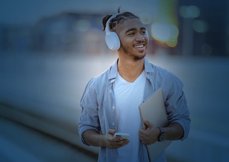 Man smiling with bluetooth wireless headphones with blue overlay | Retail logistics solutions by C.H. Robinson