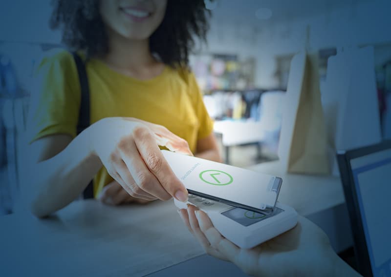 Woman paying for retail product with tap to pay technology