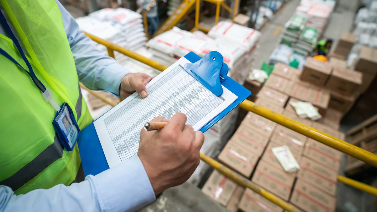 Close up of person checking a list on a clipboard