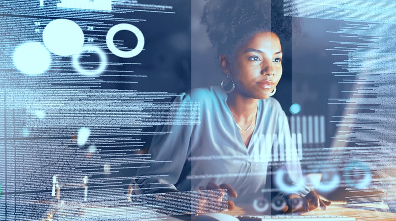 Woman sitting at computer with technology overlay